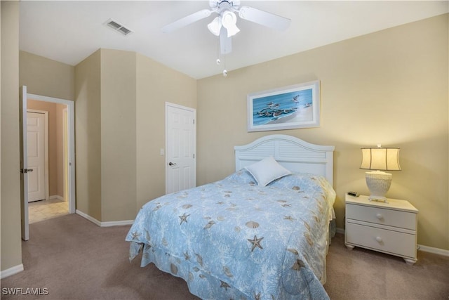 carpeted bedroom with visible vents, baseboards, and a ceiling fan