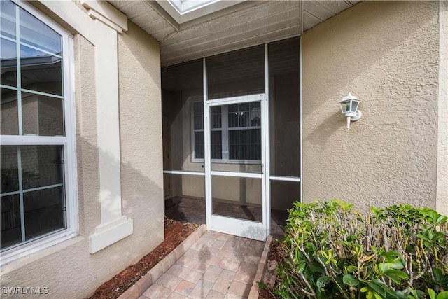 view of exterior entry with stucco siding
