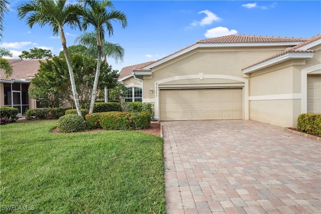 view of front of property with a garage, stucco siding, a tile roof, decorative driveway, and a front yard