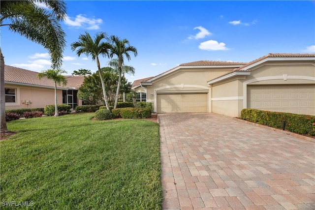 view of front of property featuring stucco siding, a tiled roof, an attached garage, decorative driveway, and a front yard