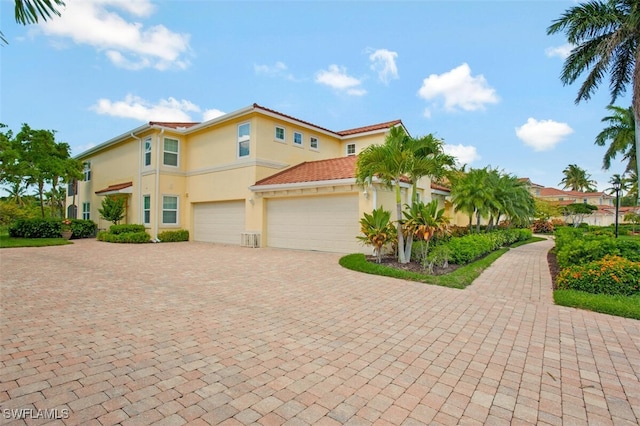 view of front of home with an attached garage, decorative driveway, and stucco siding