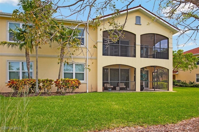 rear view of property with stucco siding and a yard