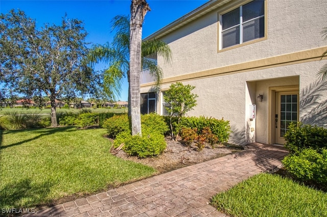 3111 Meandering Way Unit 101, Fort Myers, FL 33905 - view of side of home with stucco siding and a lawn