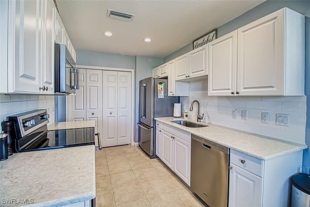 kitchen featuring stainless steel appliances, light countertops, white cabinetry, and a sink