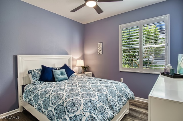 bedroom with ceiling fan, dark wood finished floors, and baseboards