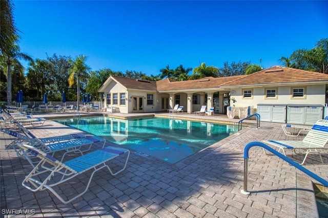 community pool with a patio area and fence