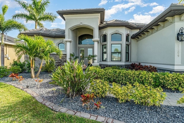 doorway to property featuring a tile roof and stucco siding