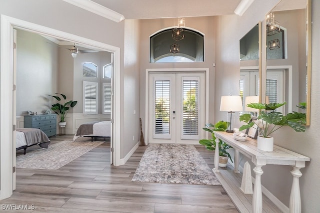 foyer featuring ornamental molding, french doors, wood finished floors, and baseboards