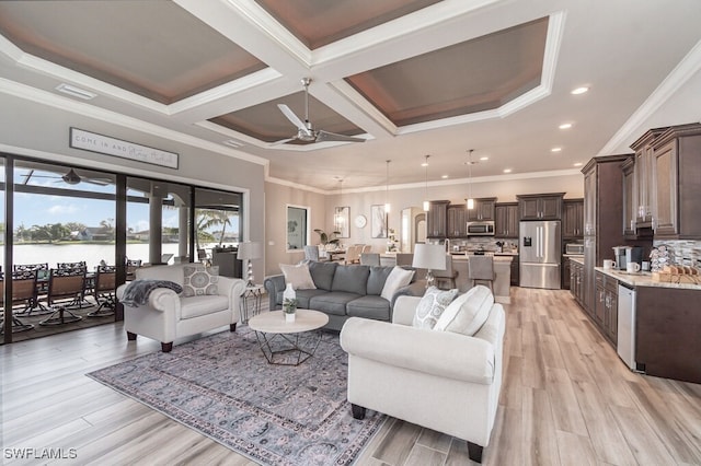 living room with light wood finished floors, visible vents, ceiling fan, a water view, and crown molding