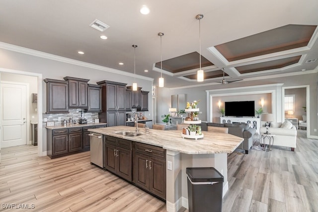 kitchen with dishwasher, open floor plan, decorative light fixtures, a kitchen island with sink, and a sink