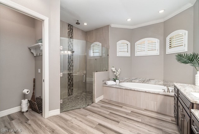 full bathroom with a stall shower, ornamental molding, wood finished floors, vanity, and a bath