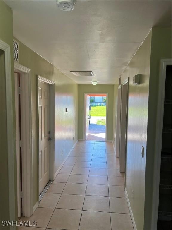 hall with light tile patterned flooring and visible vents