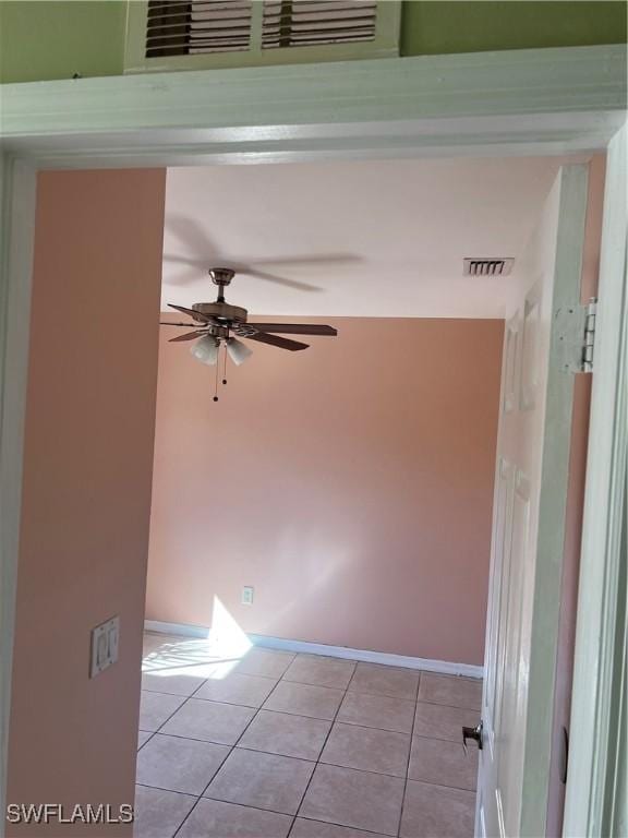 unfurnished room featuring light tile patterned floors, baseboards, visible vents, and a ceiling fan