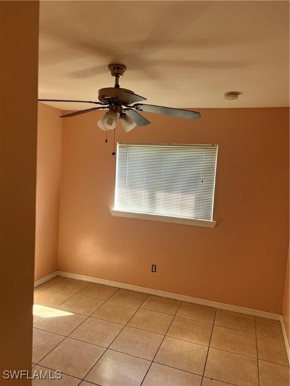 unfurnished room featuring light tile patterned floors, a ceiling fan, and baseboards