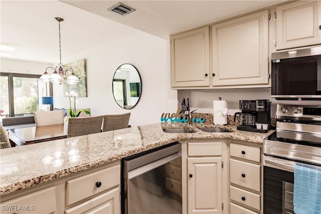 kitchen with visible vents, light stone countertops, stainless steel appliances, pendant lighting, and a sink