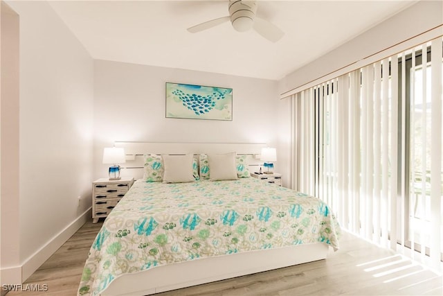 bedroom featuring light wood-type flooring, multiple windows, and baseboards