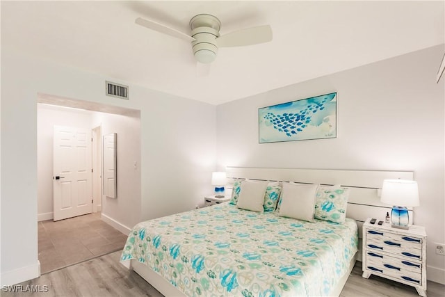 bedroom featuring a ceiling fan, baseboards, visible vents, and light wood finished floors