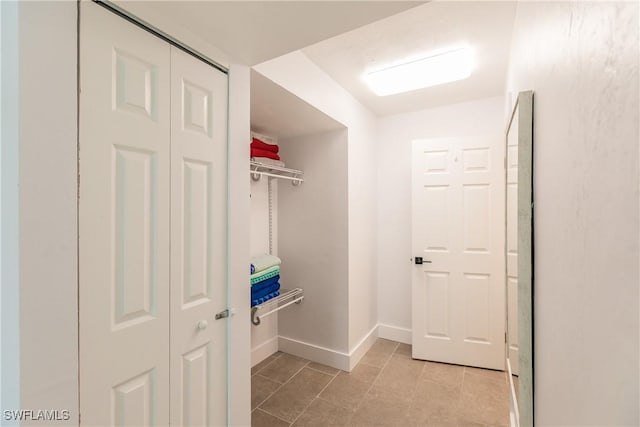 interior space with baseboards and light tile patterned flooring