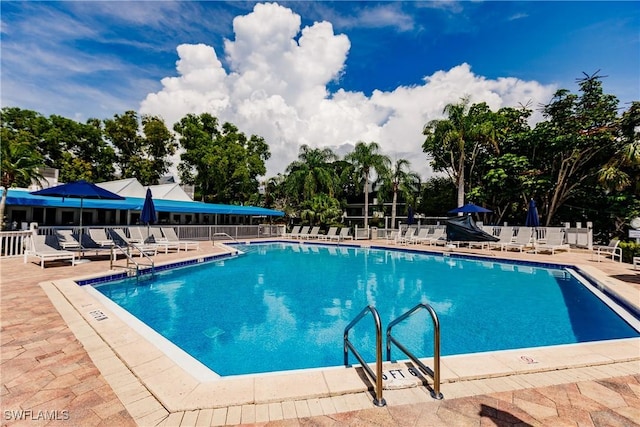 community pool with fence and a patio