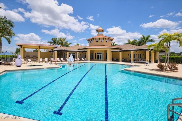 pool with a patio area and fence