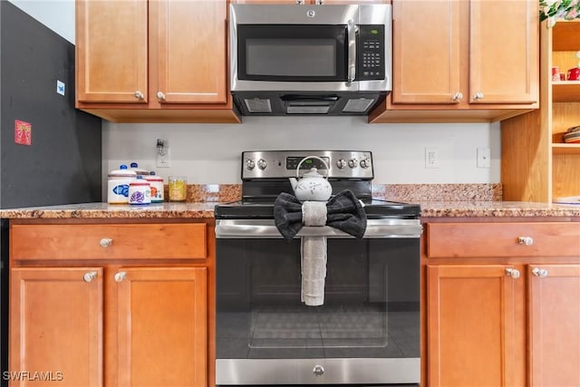 kitchen featuring appliances with stainless steel finishes, brown cabinets, open shelves, and light stone countertops