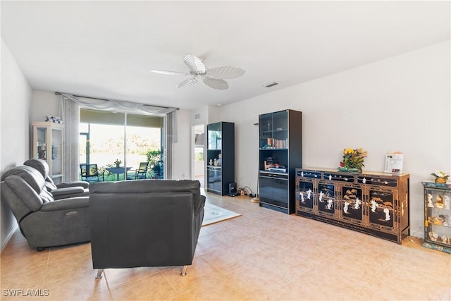 living area with visible vents, light tile patterned flooring, and a ceiling fan