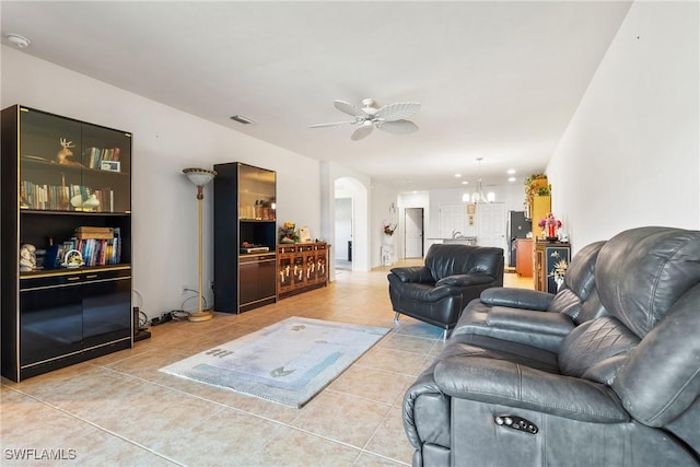 tiled living area featuring visible vents, arched walkways, and ceiling fan