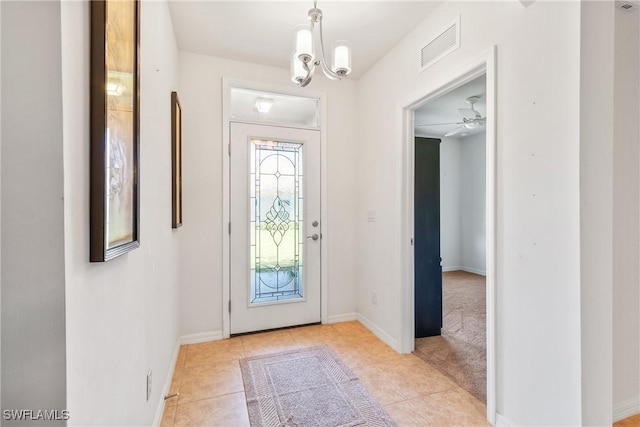 entryway with light tile patterned floors, baseboards, visible vents, and a notable chandelier