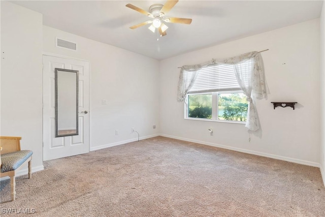 spare room featuring a ceiling fan, baseboards, visible vents, and carpet flooring