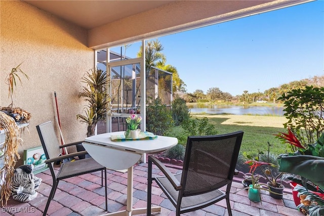 sunroom featuring a water view