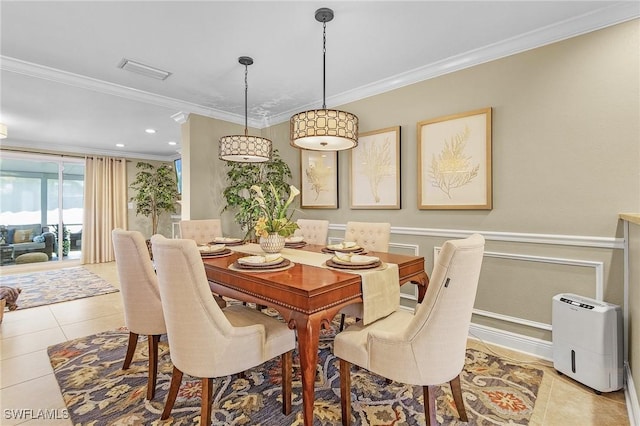 dining space featuring light tile patterned floors, visible vents, a wainscoted wall, and ornamental molding