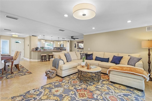 living room featuring light tile patterned floors, visible vents, ornamental molding, and recessed lighting