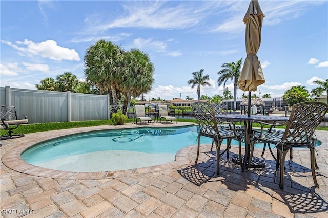 view of pool featuring a fenced in pool, a water view, fence, and a patio