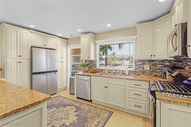 kitchen featuring light tile patterned floors, recessed lighting, a sink, appliances with stainless steel finishes, and tasteful backsplash