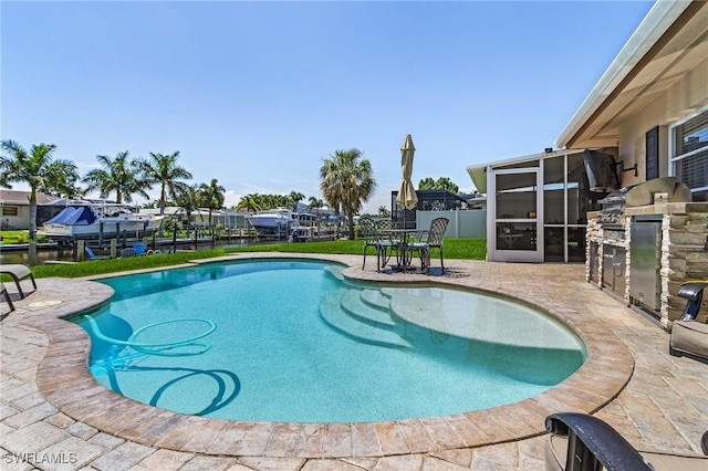 outdoor pool featuring fence, an outdoor kitchen, and a patio