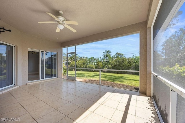 unfurnished sunroom featuring ceiling fan