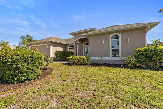 view of front facade with a garage, stucco siding, and a front yard