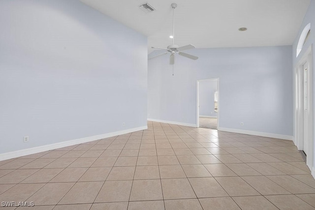 spare room with light tile patterned floors, visible vents, baseboards, ceiling fan, and high vaulted ceiling