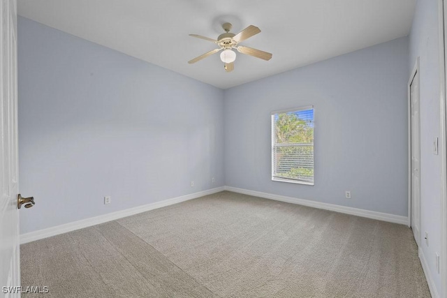 spare room with carpet floors, baseboards, and a ceiling fan