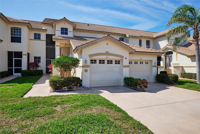 mediterranean / spanish house with an attached garage, driveway, a tiled roof, and stucco siding