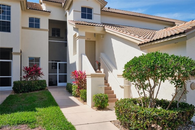 exterior space featuring a tiled roof and stucco siding