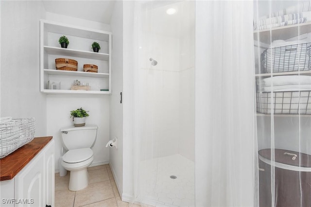 bathroom with a shower stall, toilet, and tile patterned floors