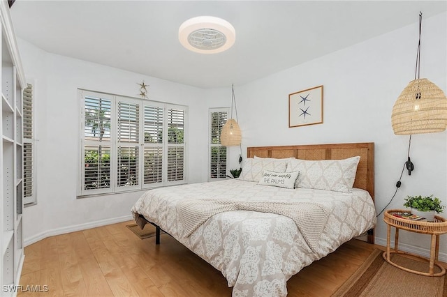 bedroom with baseboards and wood finished floors