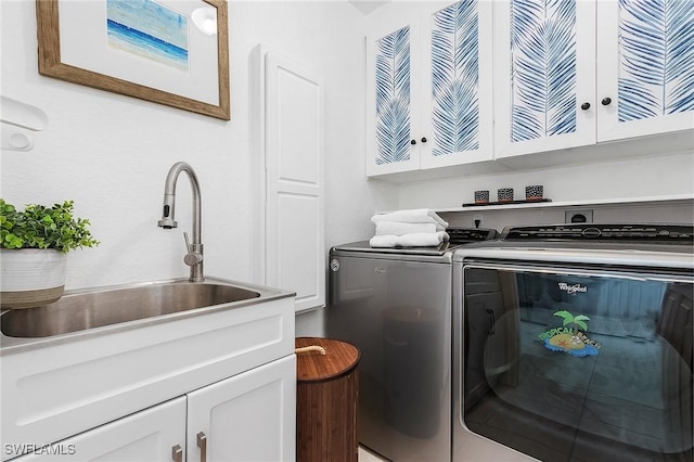 laundry room featuring cabinet space, a sink, and washer and clothes dryer