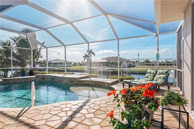 outdoor pool with a patio area, glass enclosure, and a water view