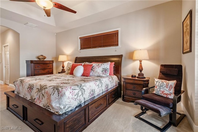 bedroom featuring light carpet, baseboards, visible vents, arched walkways, and a ceiling fan