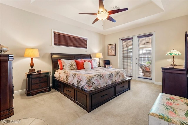 bedroom featuring light carpet, visible vents, baseboards, access to exterior, and a tray ceiling