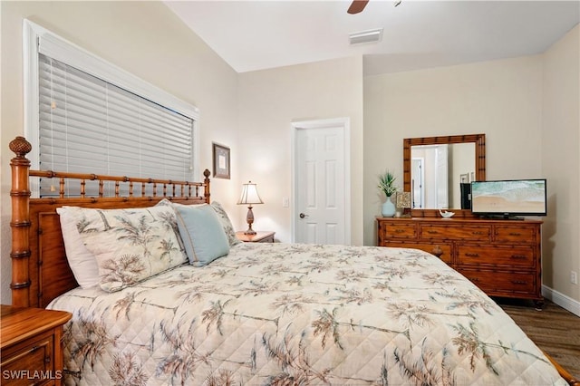 bedroom featuring ceiling fan, dark wood finished floors, visible vents, and baseboards