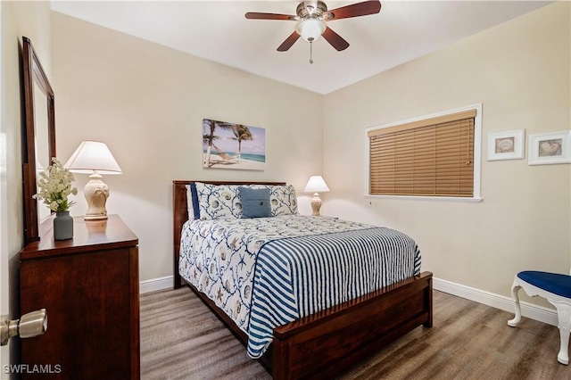 bedroom with a ceiling fan, baseboards, and wood finished floors