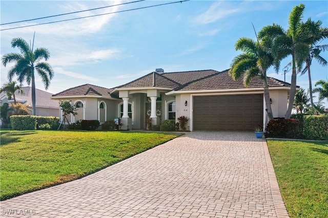 view of front facade featuring an attached garage, a front lawn, decorative driveway, and stucco siding